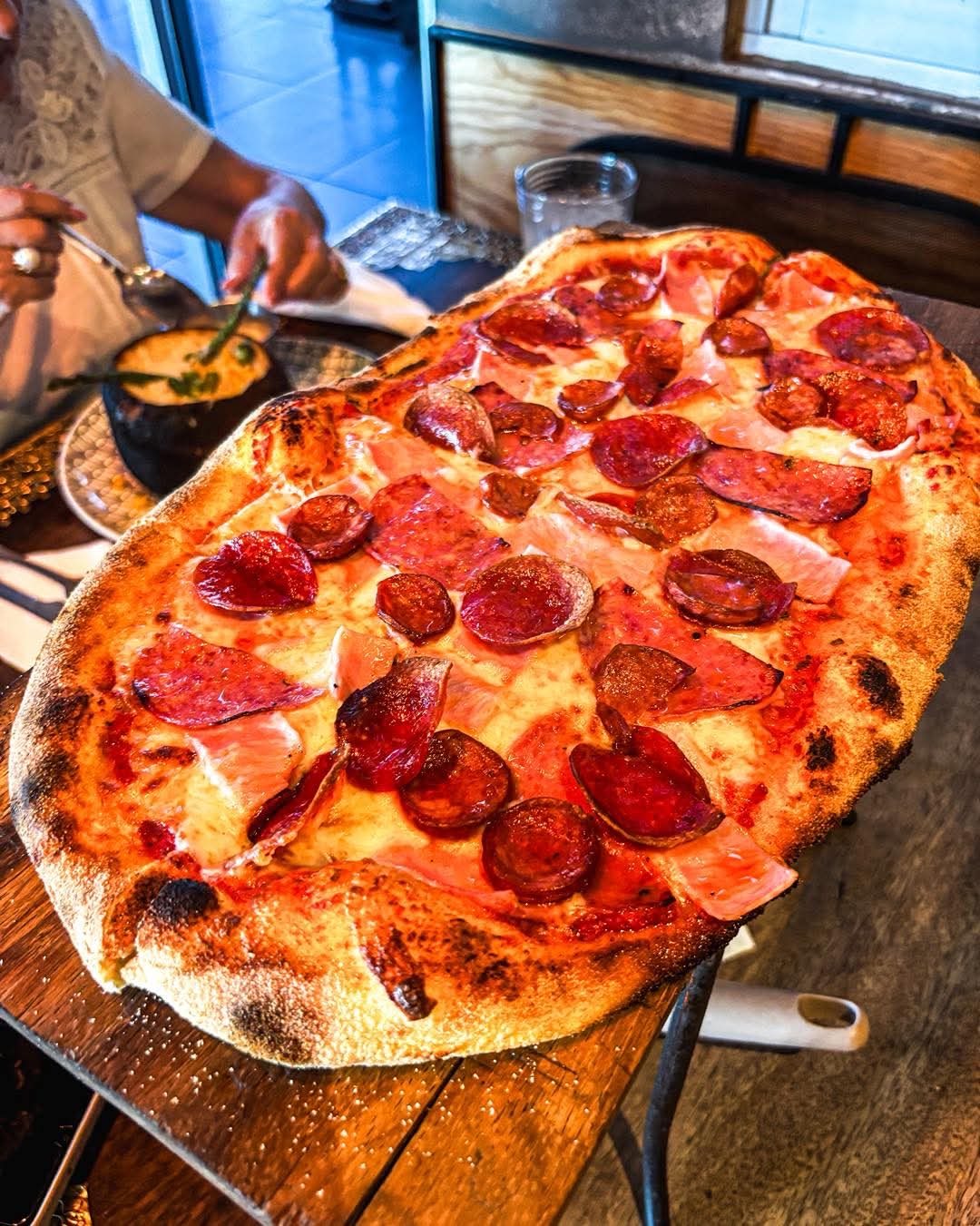 Pizza a la leña servida en Santo Olivo, Hermosillo