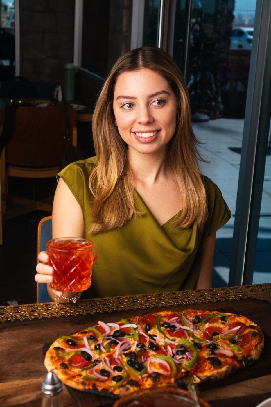 Clienta con bebida y pizza